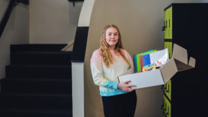 girl holds school supply pack